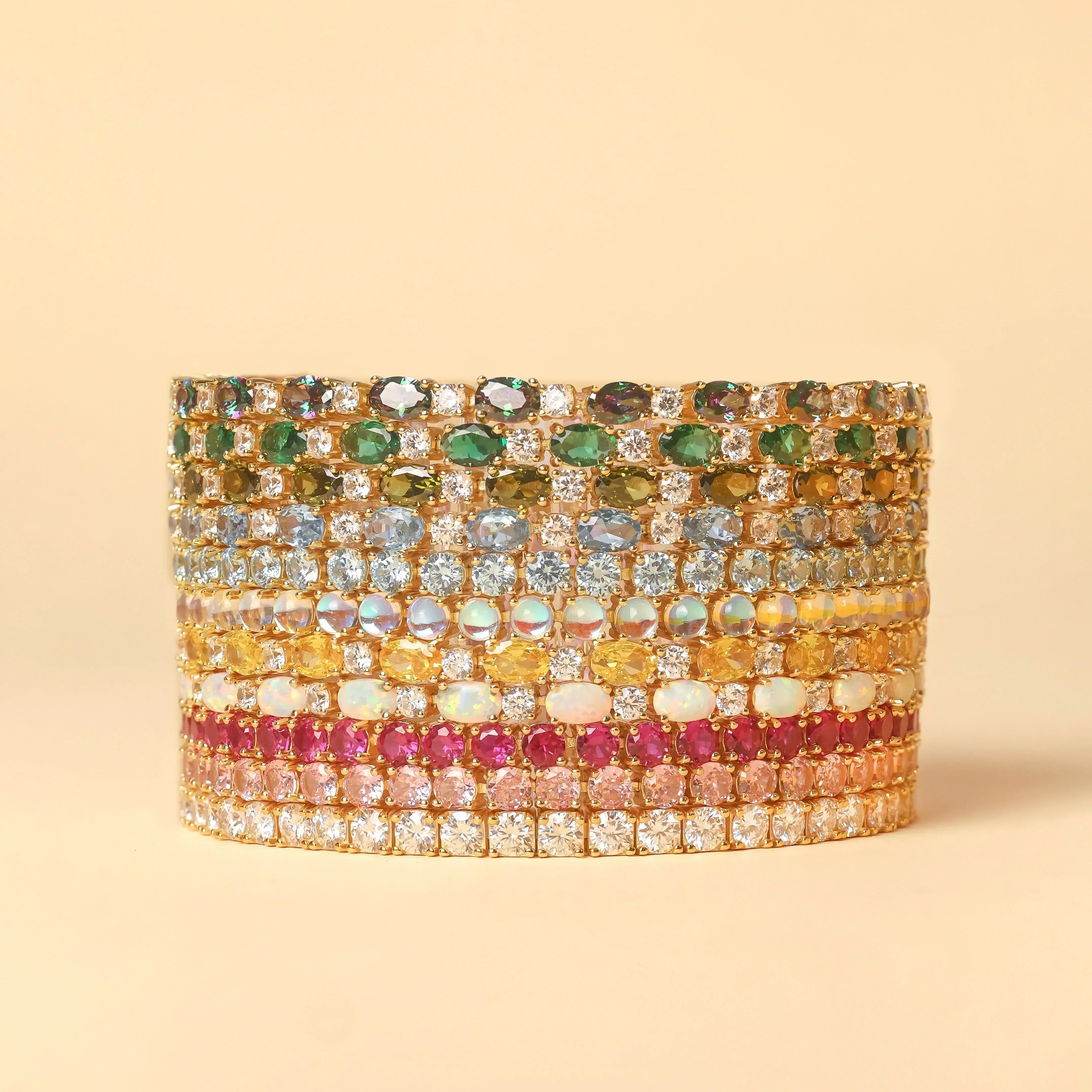 Stacked colorful gemstone rings in gold settings